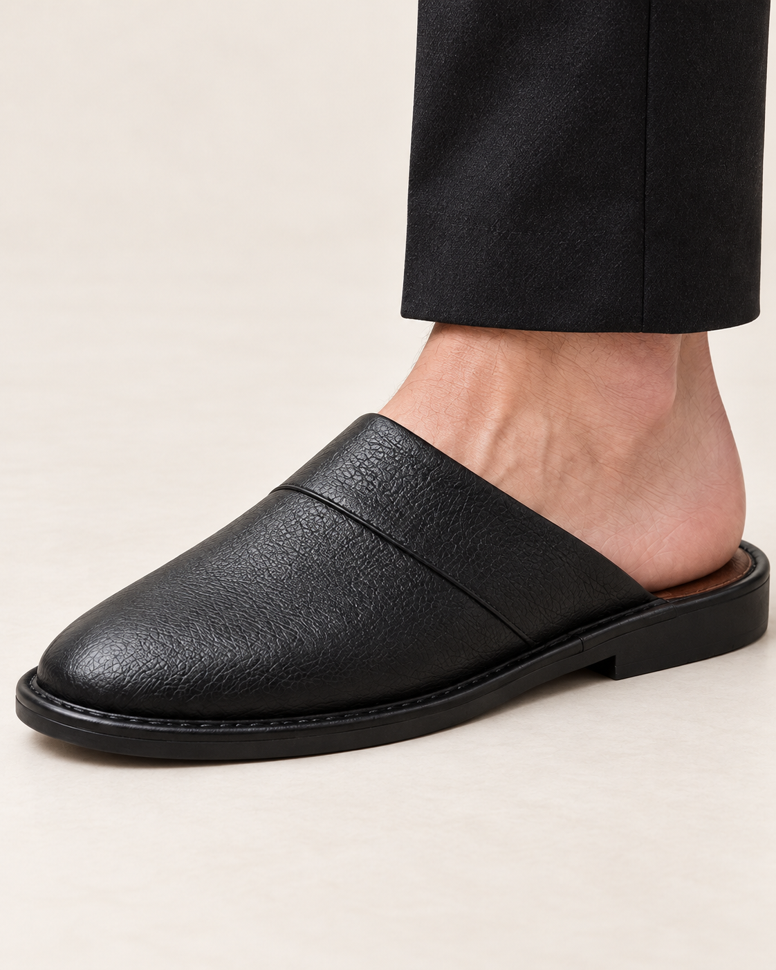 Men's black leather slipper, close-up on foot