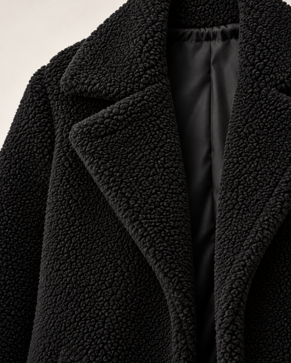 Women's black long textured jacket, lapel and lining detail