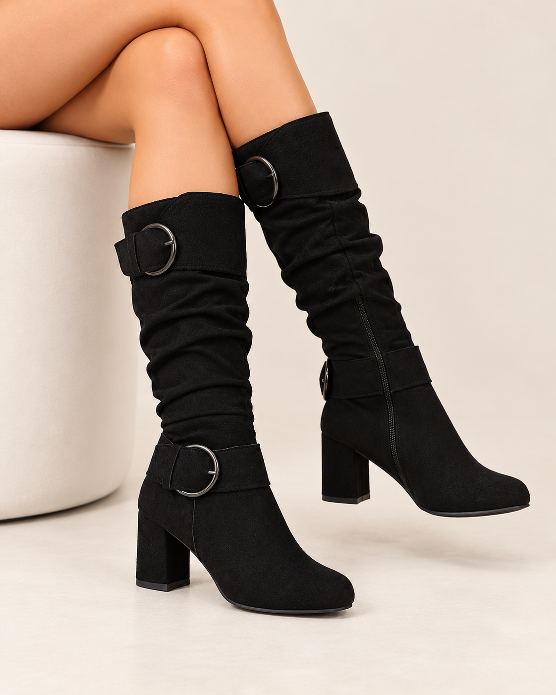 Women's knee high boots in black, seated view